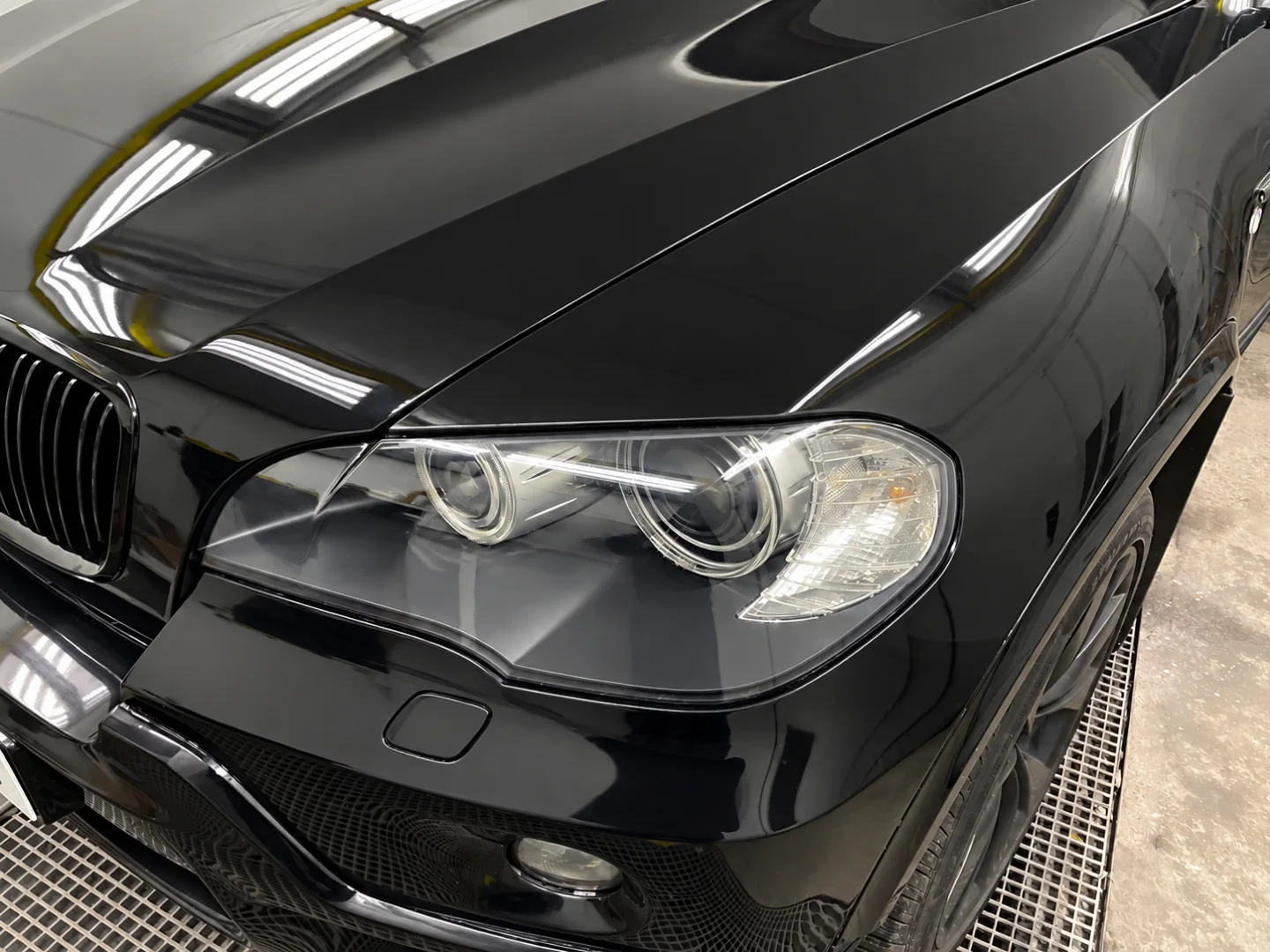 The same BMW X5 panel after machine polishing, the paint corrected to a deep mirror gloss